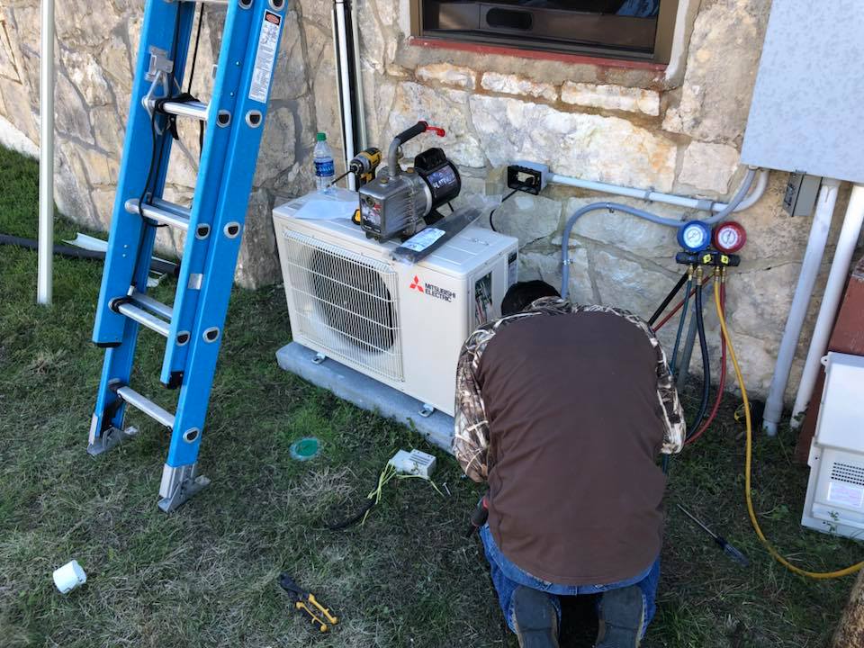 HVAC technician performing professional heat pump maintenance and inspection service in Blanco, TX