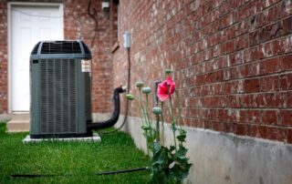 Outdoor air conditioner running beside a Texas Hill Country home in September